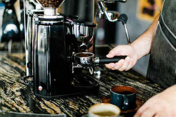 Barista Männerhände beim Mahlen von Kaffeebohnen