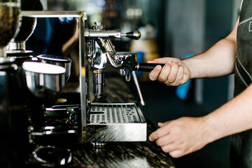 Fototapeta na wymiar Barista Männerhände machen einen Espresso an einer Espressomaschine 