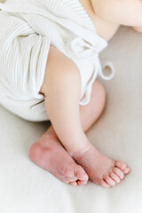 Fototapeta na wymiar puristische Babyfüße auf weißer Decke mit weißem Höschen