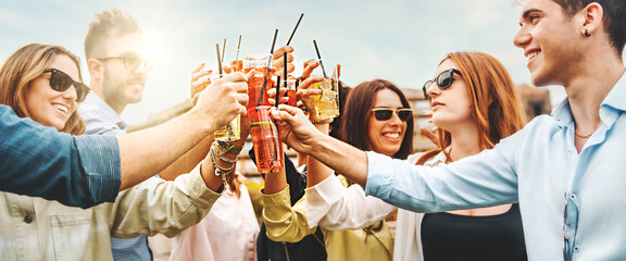 Friends toasting with colorful cocktails outdoors - obrazy, fototapety, plakaty