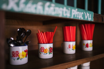 Straw and spoon display in cabinet in the wooden cabinet of the cafe