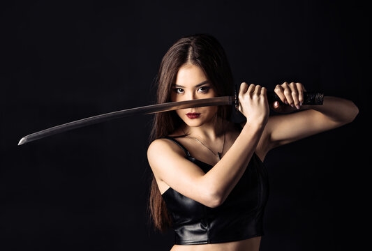 Beautiful asian woman with Japanese sword. Cropped image.