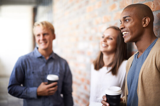 Having A Good Laugh With Colleagues. A Diverse Group Of Friends Hanging Out In A Corridor.