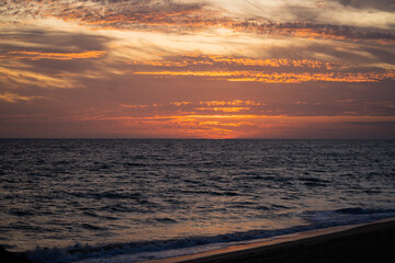 Fototapeta na wymiar Beautiful sunset over the ocean in Algarve, Portugal. The sun sets over the horizon.