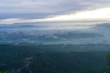 Landscape with forests in fog on the beach and village