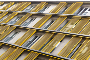 Windows of a building with yellow shutters in the old center of Budapest