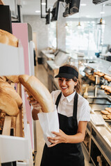 Beautiful young and happy female worker working in a modern bakery or fast food restaurant.