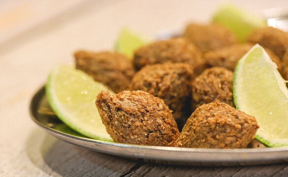Quibe Frito. Pequenos quibes com peda&ccedil;os de lim&atilde;o servidos em uma travessa. Comida brasileira, Petisco, Salgado, Salgadinho.