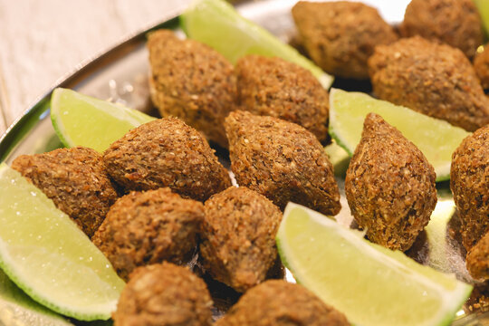 Quibe Frito. Pequenos quibes com peda&ccedil;os de lim&atilde;o servidos em uma travessa. Comida brasileira, Petisco, Salgado, Salgadinho.