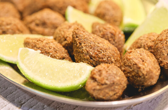 Quibe Frito. Pequenos quibes com peda&ccedil;os de lim&atilde;o servidos em uma travessa. Comida brasileira, Petisco, Salgado, Salgadinho.