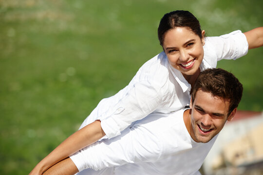 Hes my superhero. a young man giving his girlfriend a piggyback.