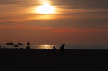 Fototapeta na wymiar Sunset at Chinchorro beach, with the red sun slowly going down