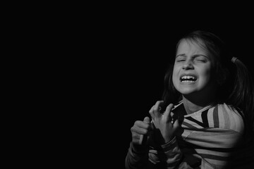 Loss childhood, pain, mental health, stress, psychology, depression, panic attacks and anxiety in children. Close up portrait of child girl screaming for help. Black and white image. Copy space.