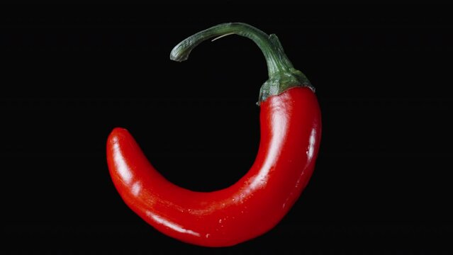 Red hot chili pepper, rotating on a black background, looped and isolated.