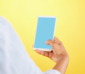 Phone mockup, hands and green screen in studio isolated on a yellow background. Cellphone, social media and black woman typing on smartphone for advertising space, marketing or product placement.