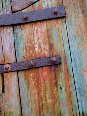 Rusted Iron straps and bolts holding an old wooden rudder together with a patina of colors