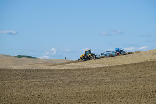 TUSCANY, ITALY-SEPTEMBER 21, 2017: Tracked tractor Challenger MT765D with pneumatic seed drill Lemken Solitair 9 in the field on a sunny Septem