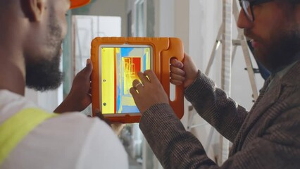 Electrician inspector and builder using a thermal imaging camera on tablet pc. Realtime