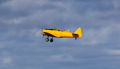 Small old plane in the air. Blue sky background.