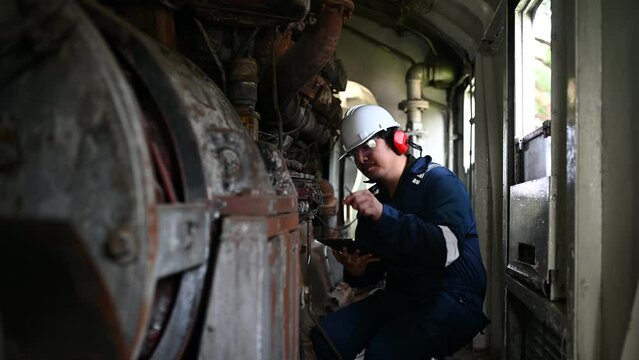 Engine engineer inspecting large machines in factory,Railway engine maintenance technician,engine repair mechanical manager