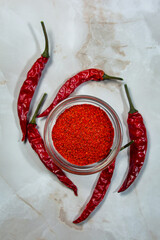 Hot ground pepper and dried chili peppers nearby