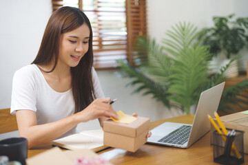 Asian woman preparing package delivery box Shipping for shopping online. young start up small business owner 