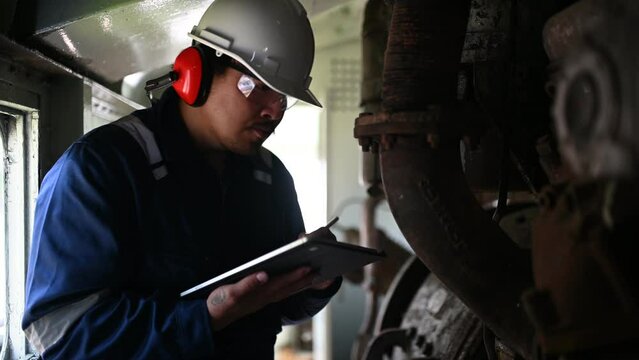 Engine engineer inspecting large machines in factory,Railway engine maintenance technician,engine repair mechanical manager