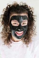  woman with a black facial mask at home