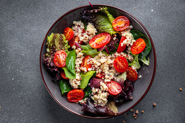 quinoa salad tomato, green lettuce mix healthy meal food snack on the table copy space food background rustic top view keto or paleo diet veggie vegan or vegetarian food