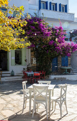 Outdoors cafe on paved yard at Tinos island, Dio Choria village Cyclades Greece. Vertical