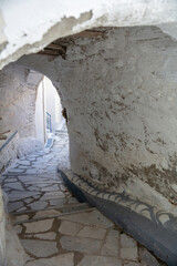 Tinos island Greece. Kardiani village, arched stonewall cover narrow cobblestone alley