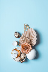 Modern creative composition with easter eggs, palm leaves and flowers top view. Easter flat lay