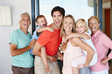 Having so much fun together. Portrait of a loving multi-generational family standing together at home.