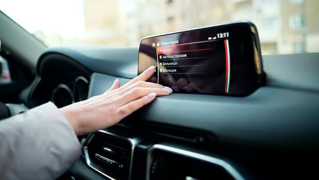 driver interacts with navigation screen on car dashboard