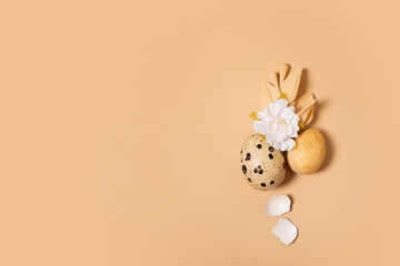 Monochrome flat lay Easter eggs minimalistic composition decoration with twigs and flower. Easter still life golden beige