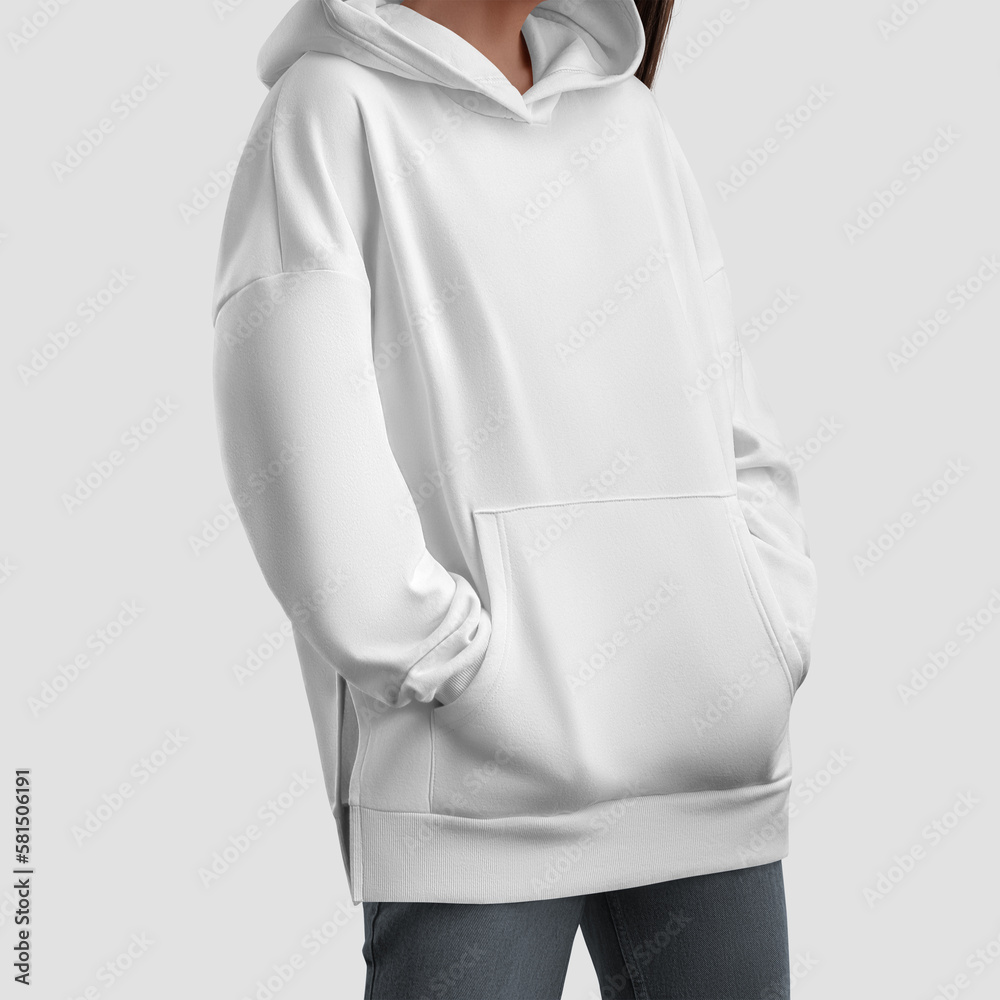 Wall mural Mockup of white long hoodie on girl with hands in pockets, oversized shirt, women's longsleeve with side slits, for design, branding.