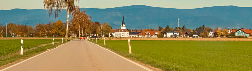 Fototapeta na wymiar Autumn or indian summer view with a church and the Bavarian forest in the background near Strasskirchen, Bavaria, Germany