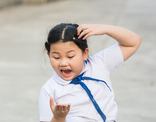 Child student fierce, mad, maniac, maniacal, rabid, wild because lice on the head,she is symptoms itching,scratch head for lice and frightened,agape