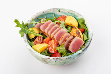 Poke bowl with tuna, cherry tomatoes, arugula, spinach, herbs, fried pineapples and soy sauce. Round bowl on a white background. Close up 3/4/