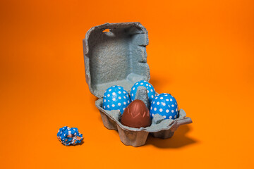 Closeup of a carton egg carton with blue with white dots eggs