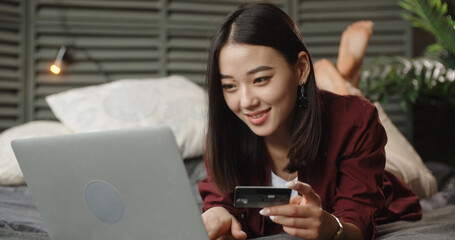 young chinese woman using laptop and holding credit card, online shopping concept Donate Charity Give Help Offering Volunteer Concept