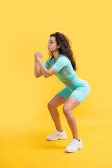 Fototapeta na wymiar fitness sportswoman squatting in sportswear at studio. fitness sportswoman in sportswear squatting