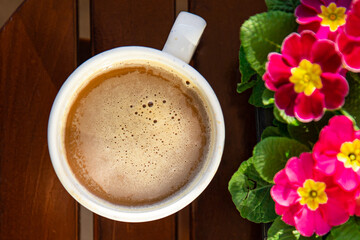 cup of coffee on the table outdoor and flowers primrose multicolored copy space food background rustic top view