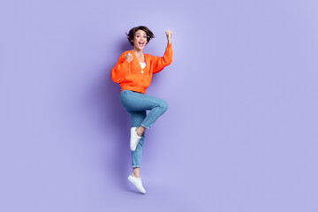Fototapeta na wymiar Full body length photo of overjoyed funny positive girl jump fists celebrate victory her exam successfully done isolated on purple color background