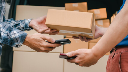 Obraz na płótnie Canvas Close up logistic worker delivering cardboard boxes to recipient at home door. Scan QR code