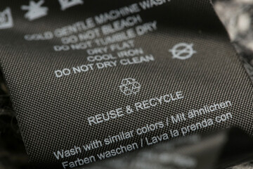 Fabric composition label, Washing instructions and recycling sign on black fabric label. Laundry...