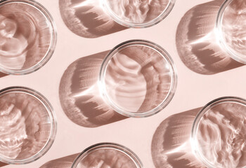 petri dish with liquid water on plain beige background water ripple texture