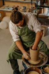 Fototapeta na wymiar Pottery workshop A potter works with clay on a potter's wheel pottery tools