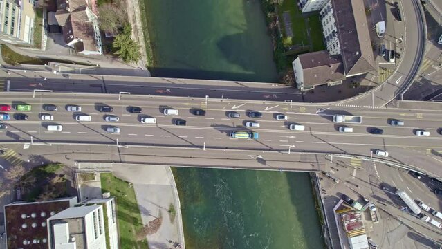 Aerial view of City of Zürich with heavy traffic on Hard Bridge over Limmat River on a blue cloudy late winter day. Movie shot March 15th, 2023, Zurich, Switzerland.