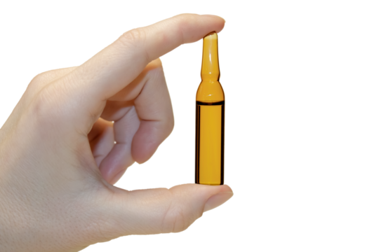 A woman holds an injection vial in her hand. The concept of medicine and cosmetic procedures.